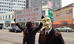 Надпись на плакате: "Культ сайентологии - это жульничество"